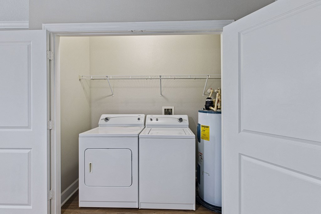 a laundry room with a washer and dryer and a door open to it