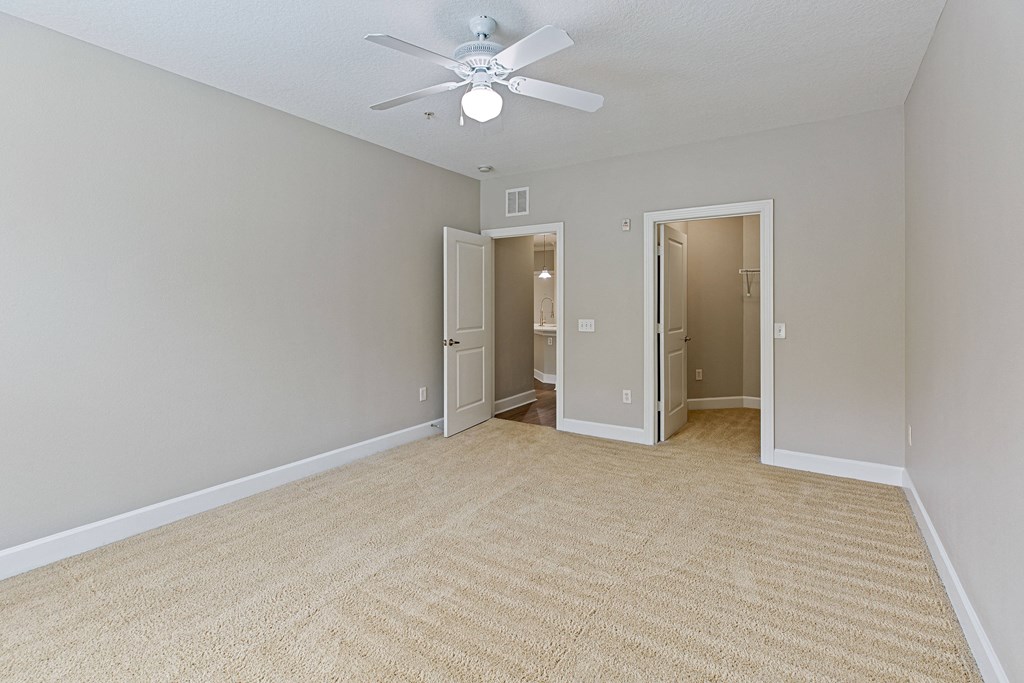 an empty living room with a ceiling fan