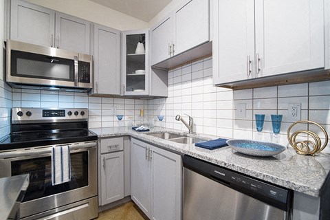 a kitchen with stainless steel appliances and white cabinets