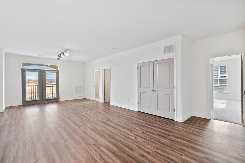 an empty living room with white walls and wood flooring