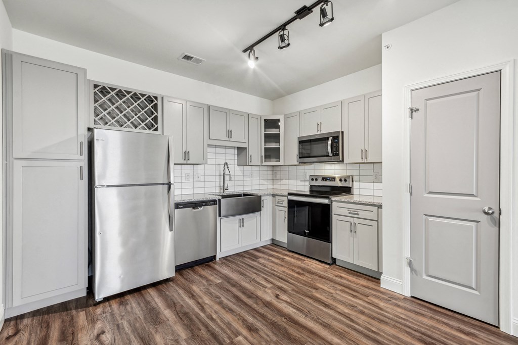 a white kitchen with stainless steel appliances and white cabinets