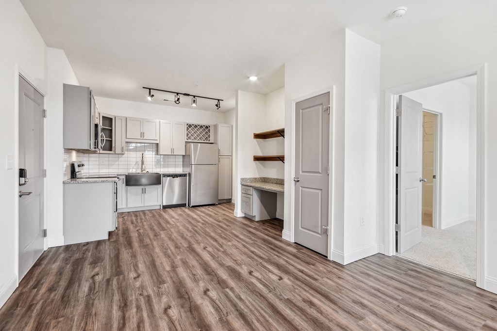 an open living room and kitchen with a hard wood floor