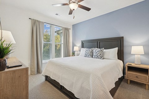a bedroom with a large bed and a ceiling fan
