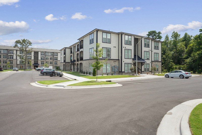 a large apartment building with cars parked in front of it