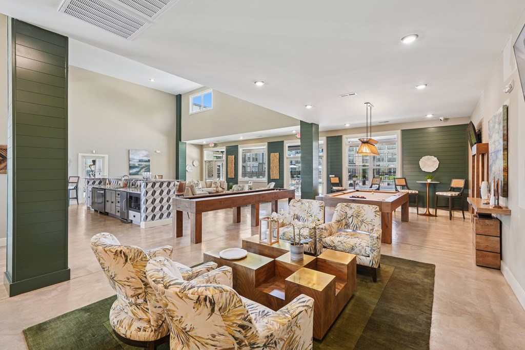 A living room with a green rug and a wooden coffee table.