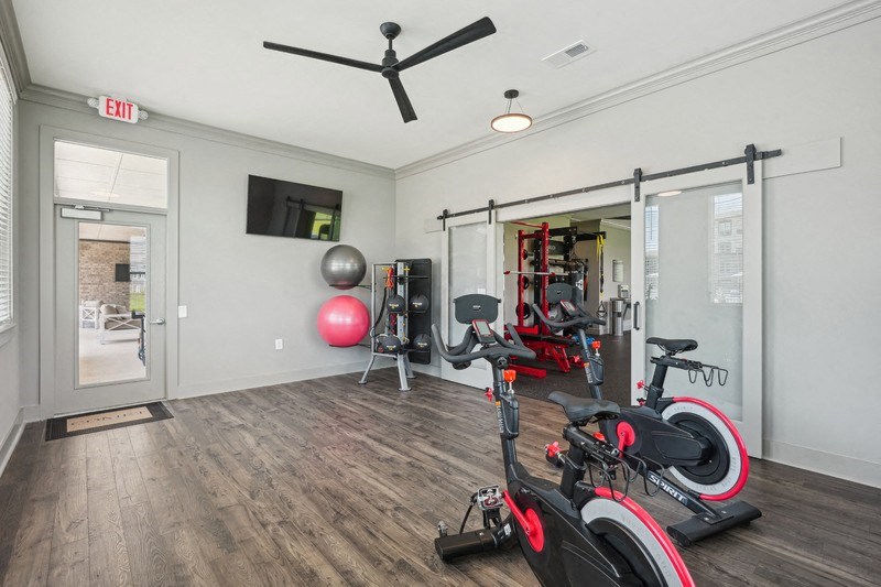 the residence apartments fitness center with exercise equipment and tv