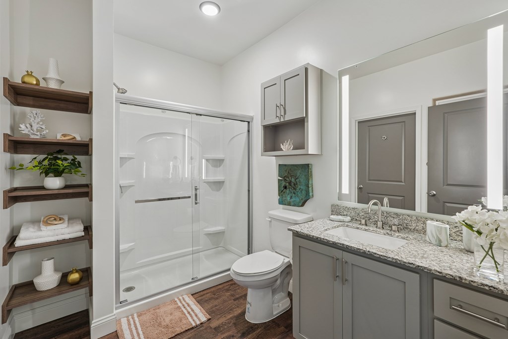 A bathroom with a toilet, sink, and shower.