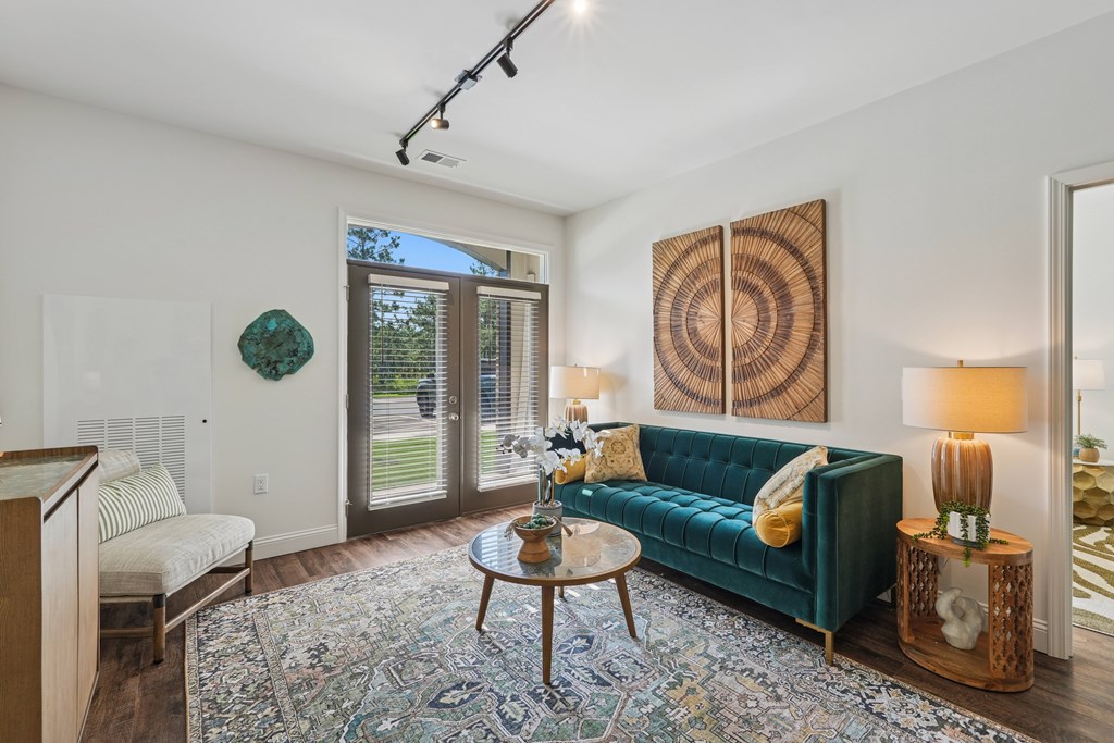 A living room with a green couch and a rug.