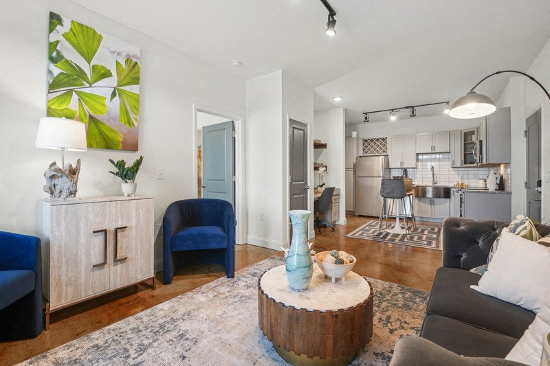 a living room with furniture and a kitchen in the background