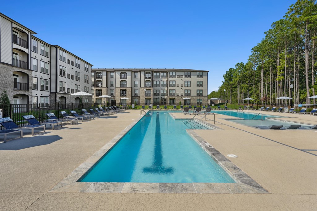 A large swimming pool in front of apartment buildings.