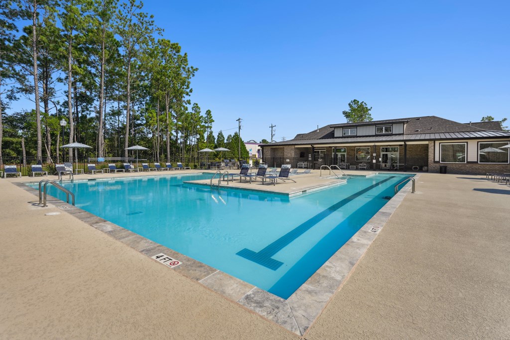A large outdoor swimming pool with a building in the background.