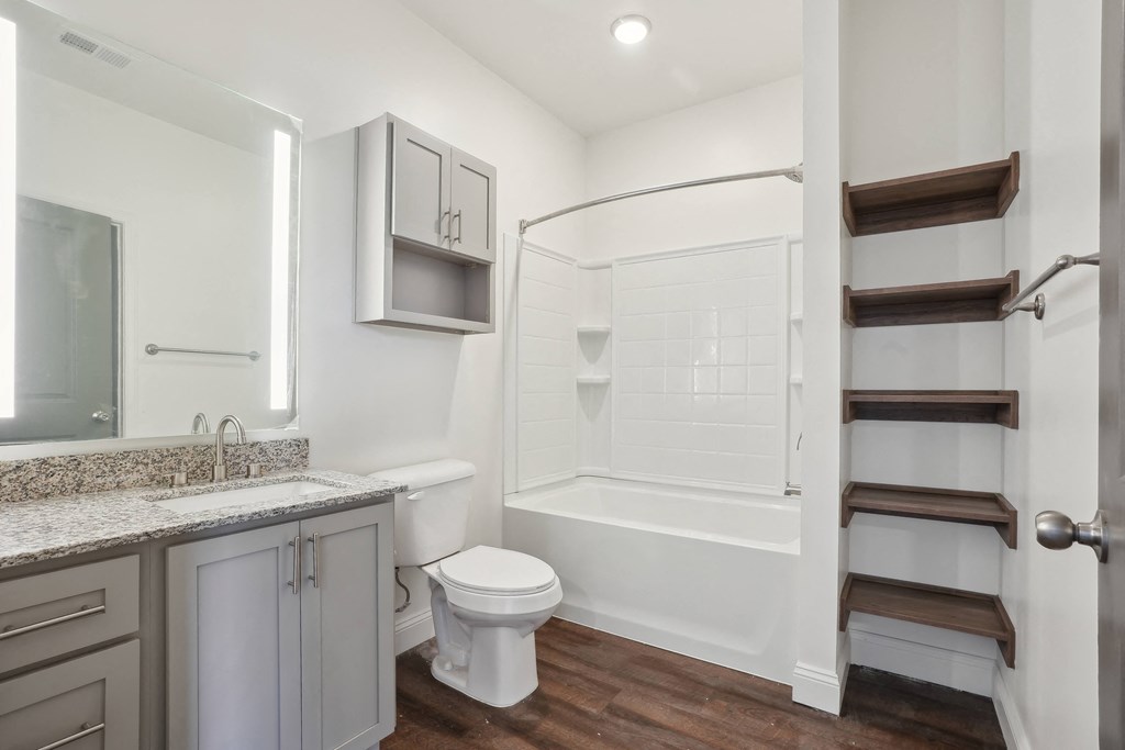 a white bathroom with a shower toilet and sink