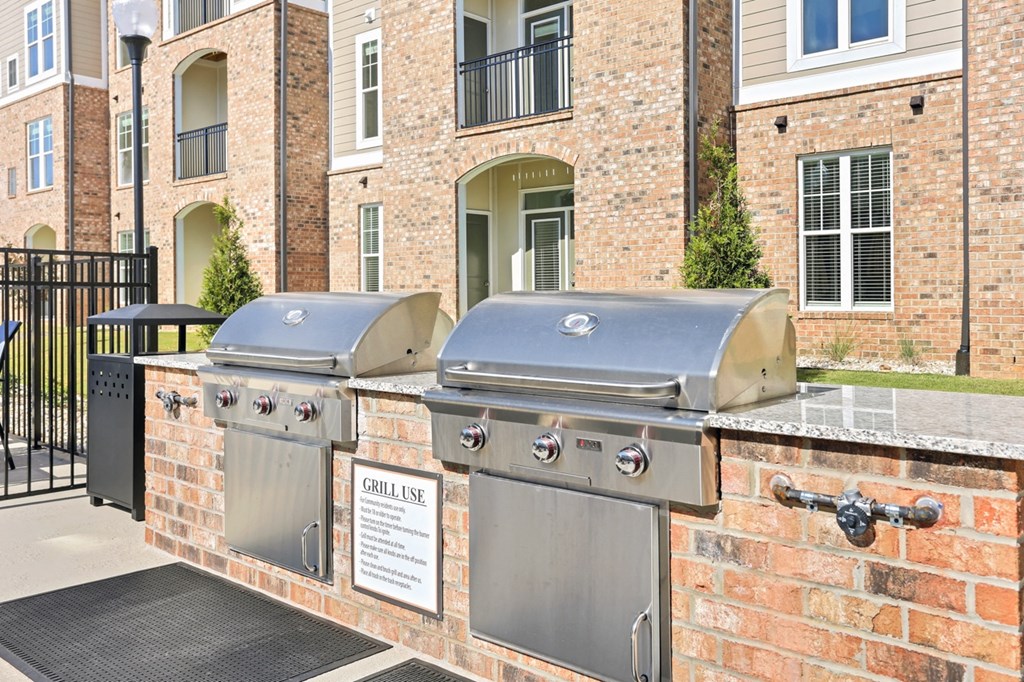 two bbq grills in front of an apartment building