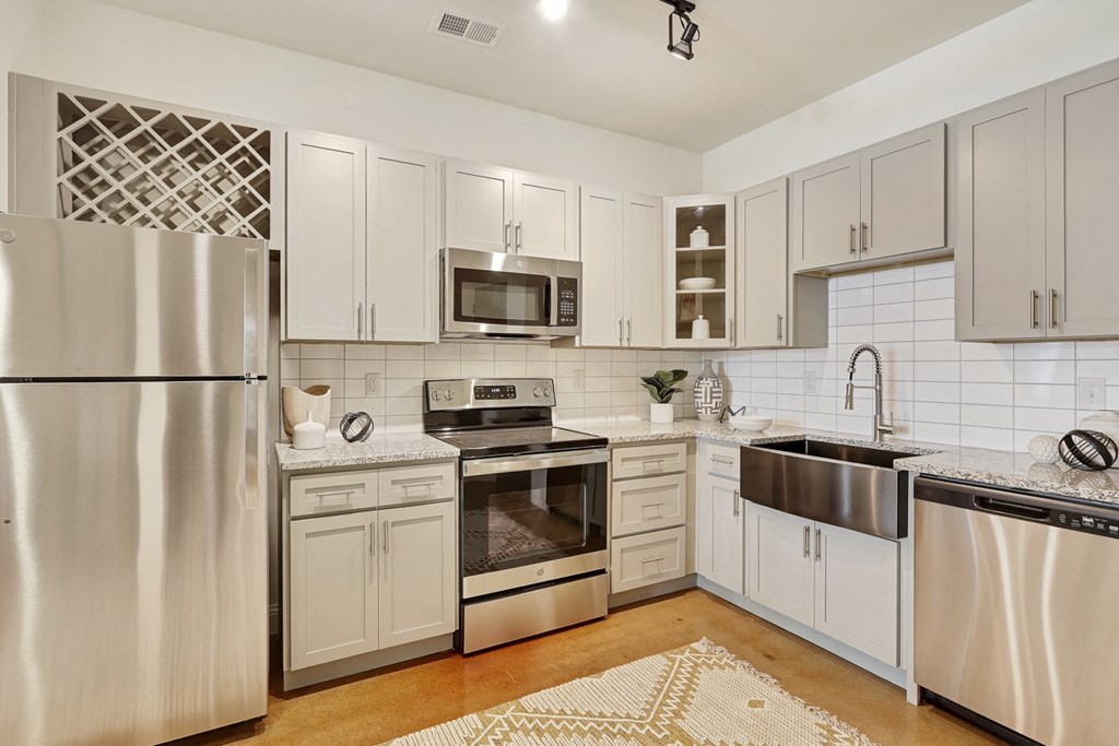 a kitchen with stainless steel appliances and white cabinets
