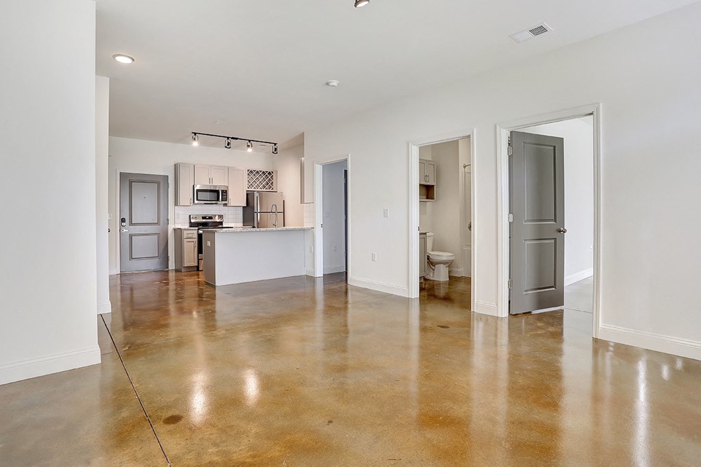 an empty living room with a kitchen