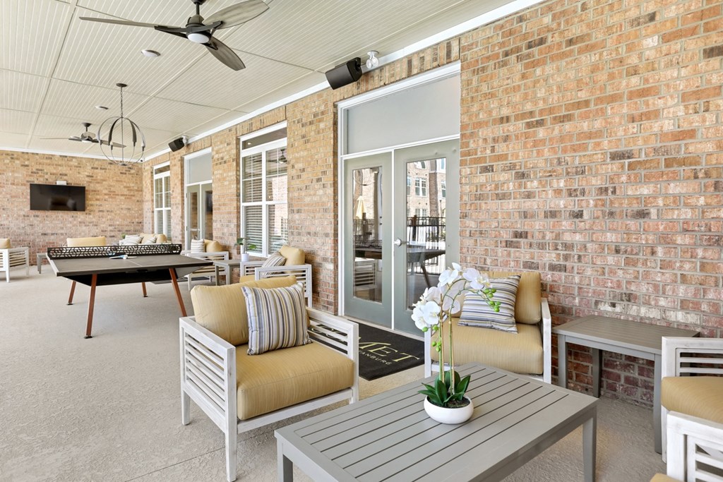 an outdoor lounge with chairs and a table