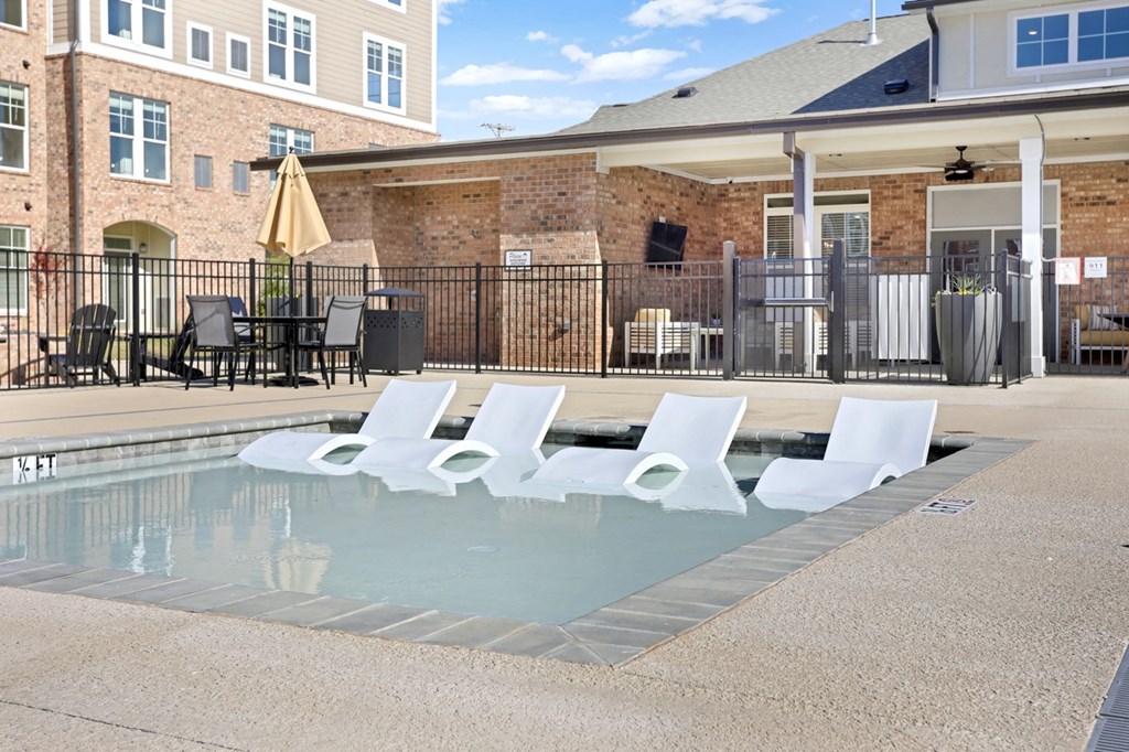 a pool with lounge chairs
