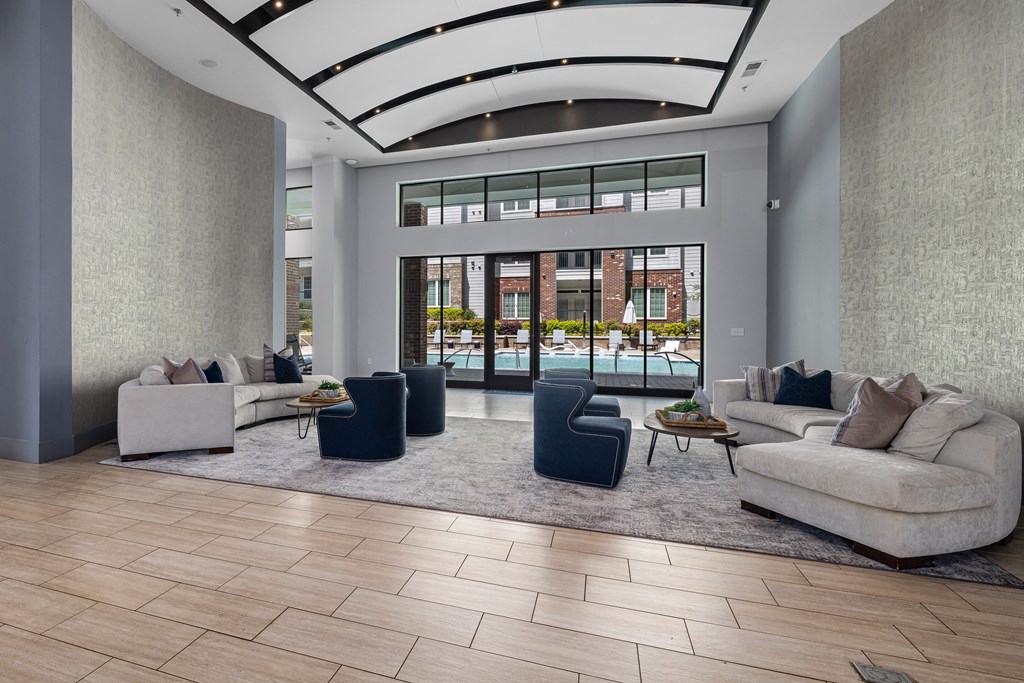 a living room with couches and chairs in front of a glass door