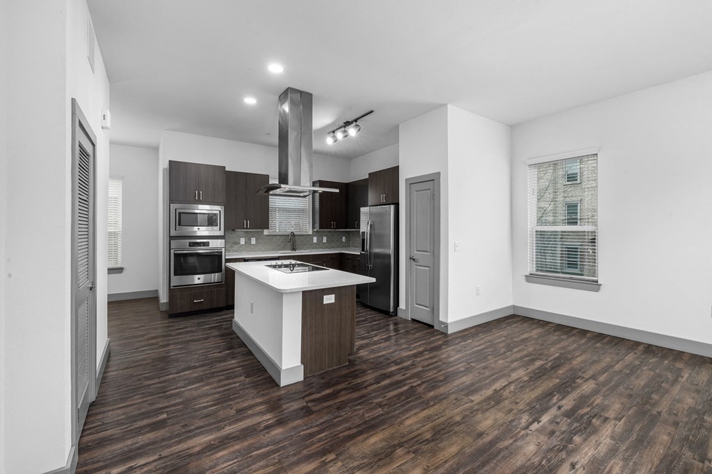 a kitchen with a large island and stainless steel appliances
