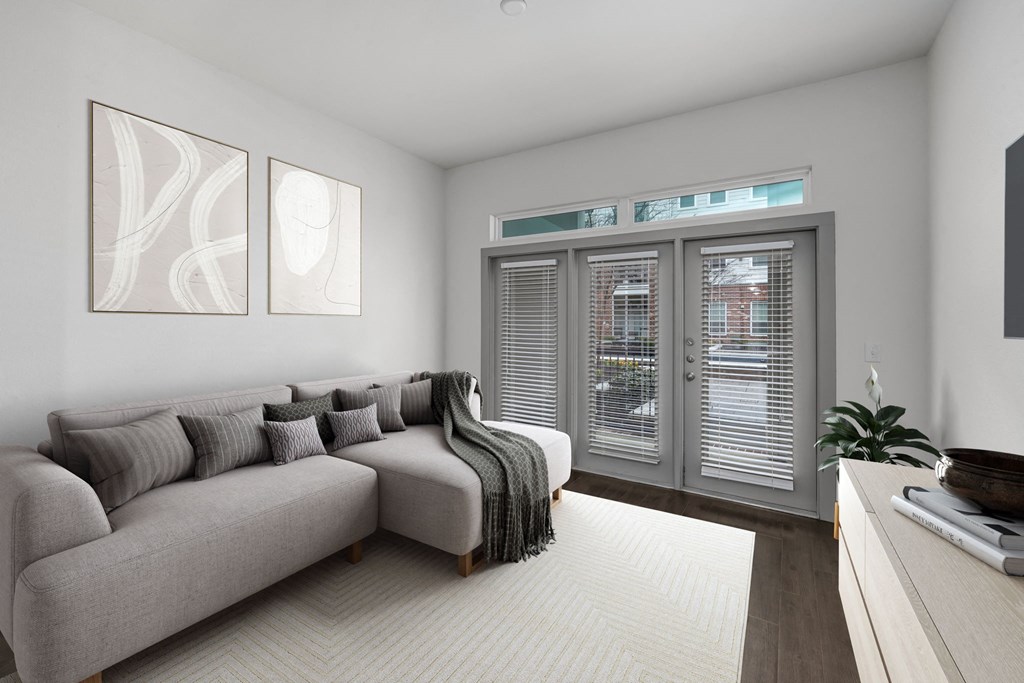 a living room with a gray couch and a large window