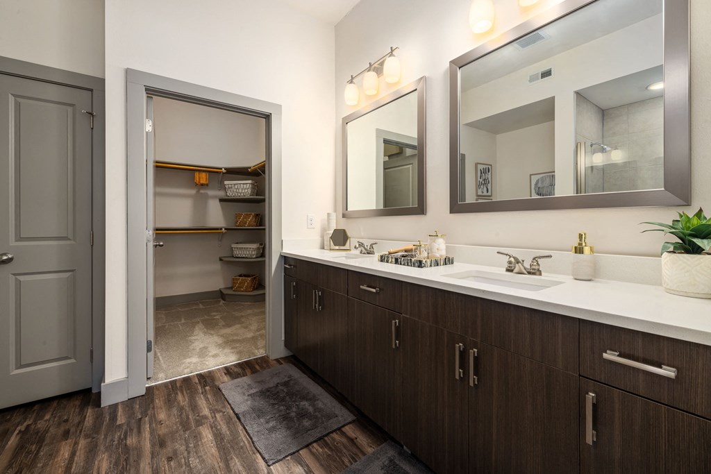 a bathroom with two sinks and a walk in closet
