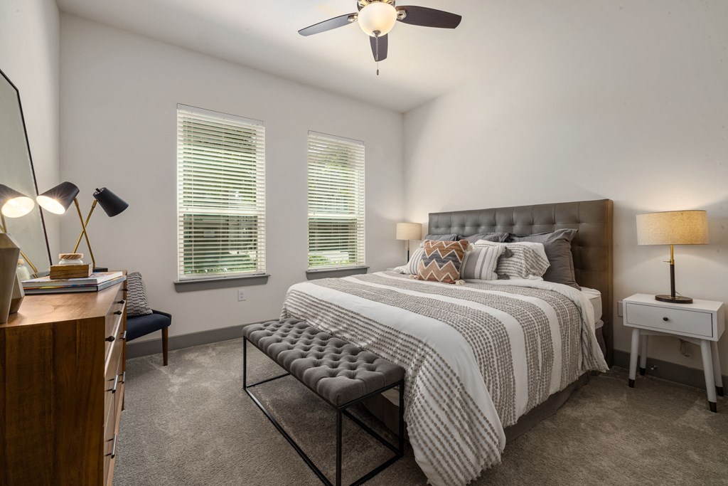 a bedroom with a bed and two windows