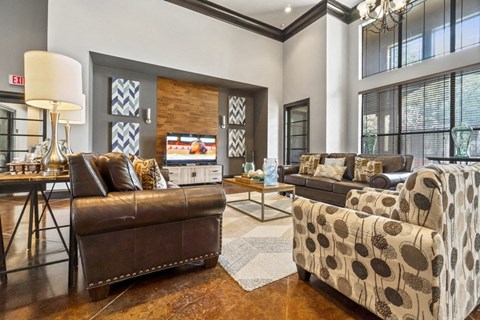 a living room with couches and chairs and a tv