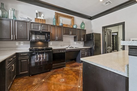 a large kitchen with black appliances and white counter tops