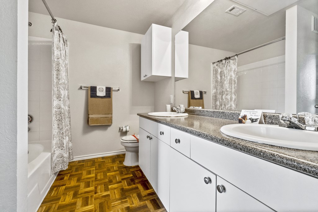 bathroom with white cabinets and a sink, mirror, toilet, and shower curtain