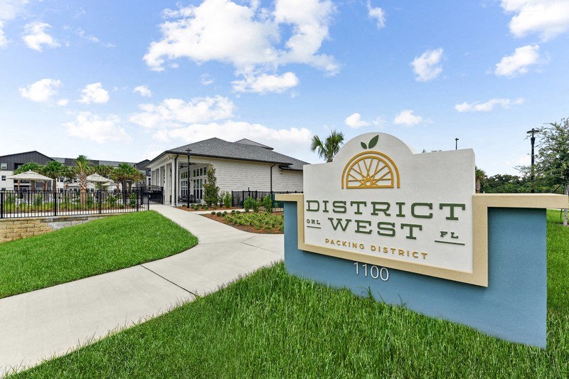 a sign for district west with a building in the background