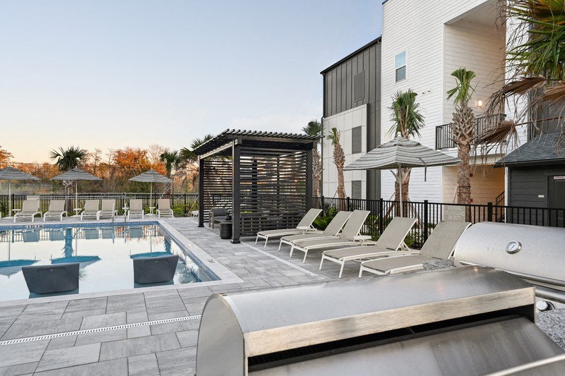 A pool area with sun loungers and a slide.