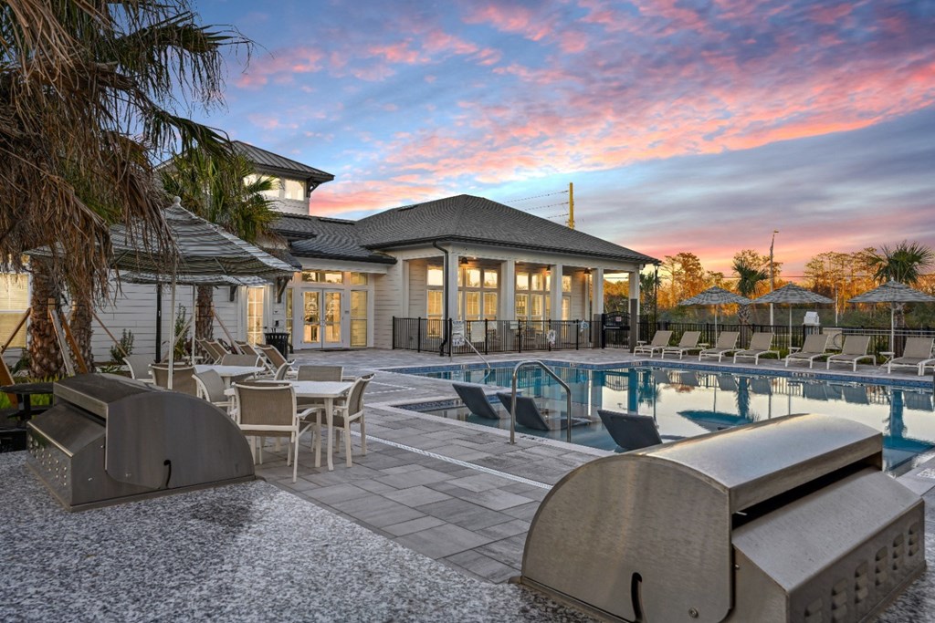 A modern house with a pool and lounge chairs.