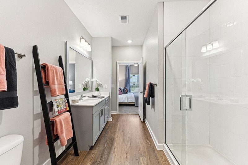 a bathroom with a glass shower and a sink and a mirror
