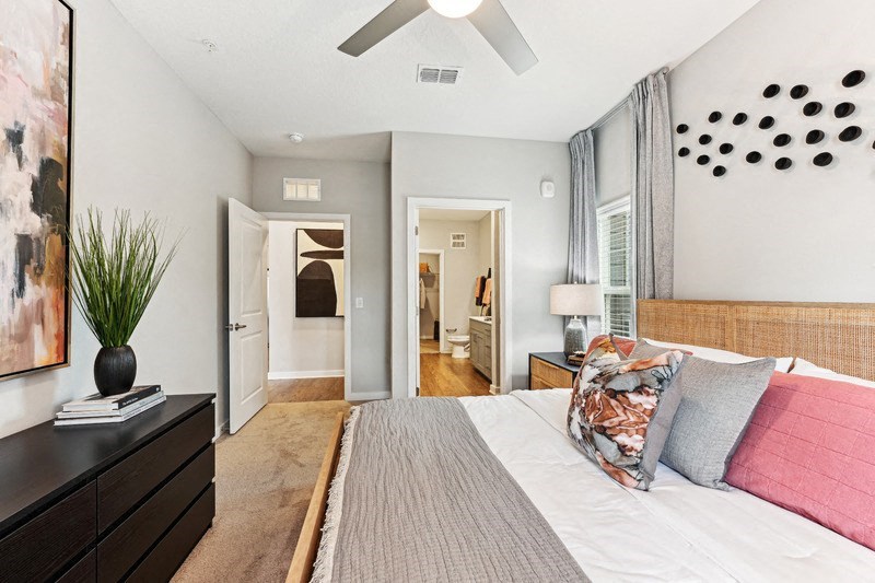 a bedroom with a large bed and a ceiling fan