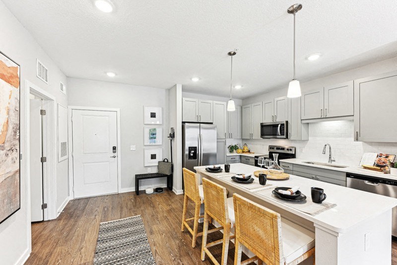a large kitchen with a large island with chairs and a counter top