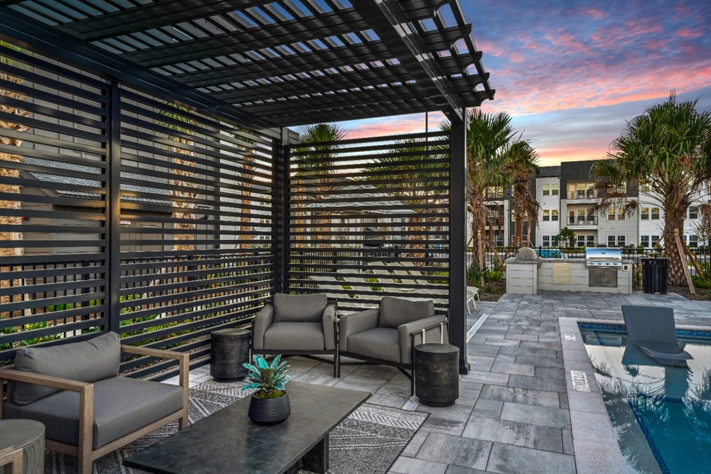 A patio with a table and chairs under a pergola.
