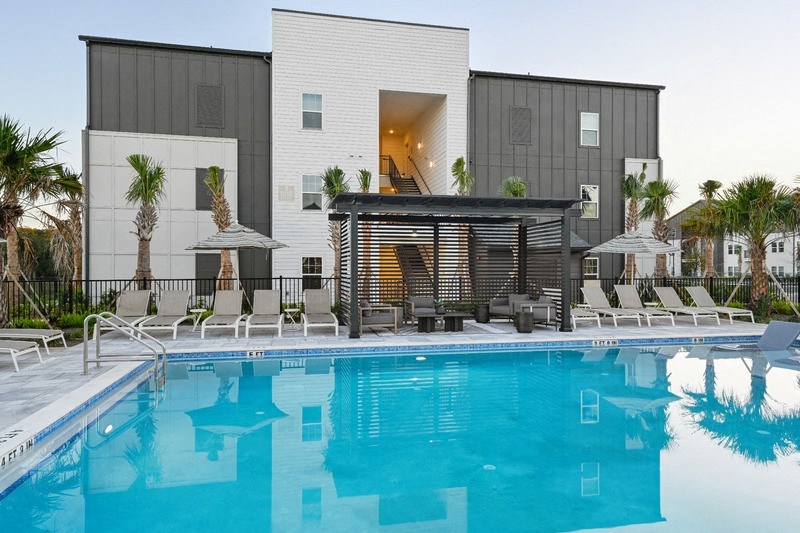 A modern house with a pool in front.