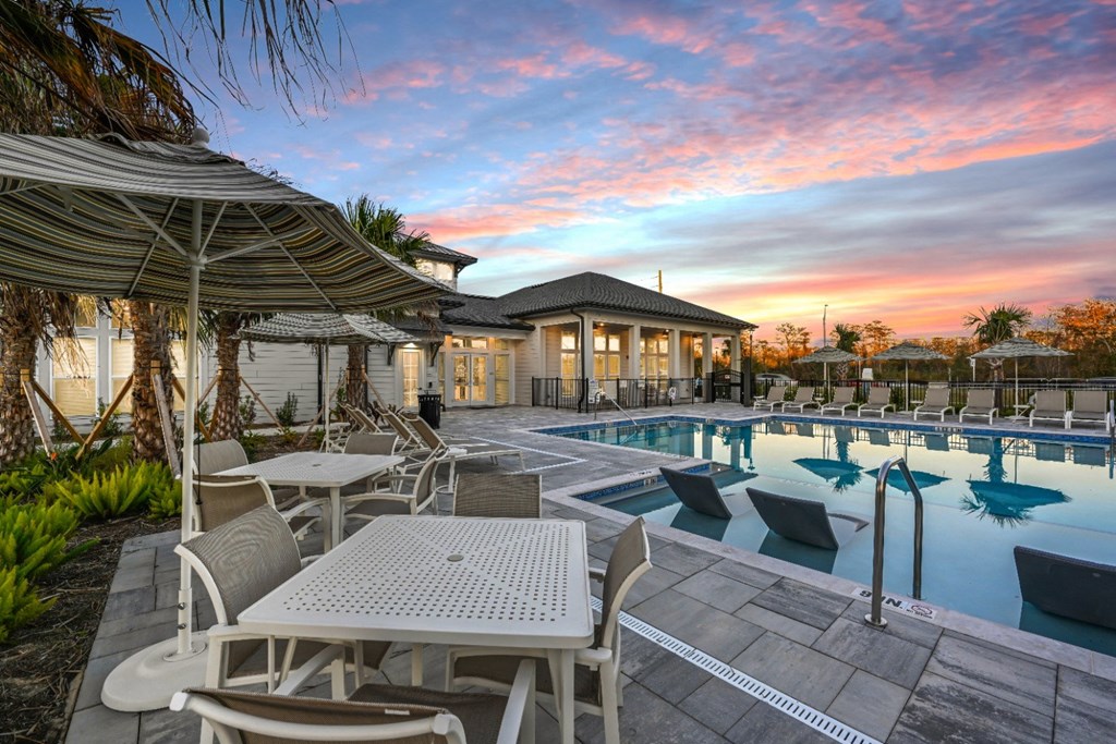 A poolside table and chairs are set up under a canopy.