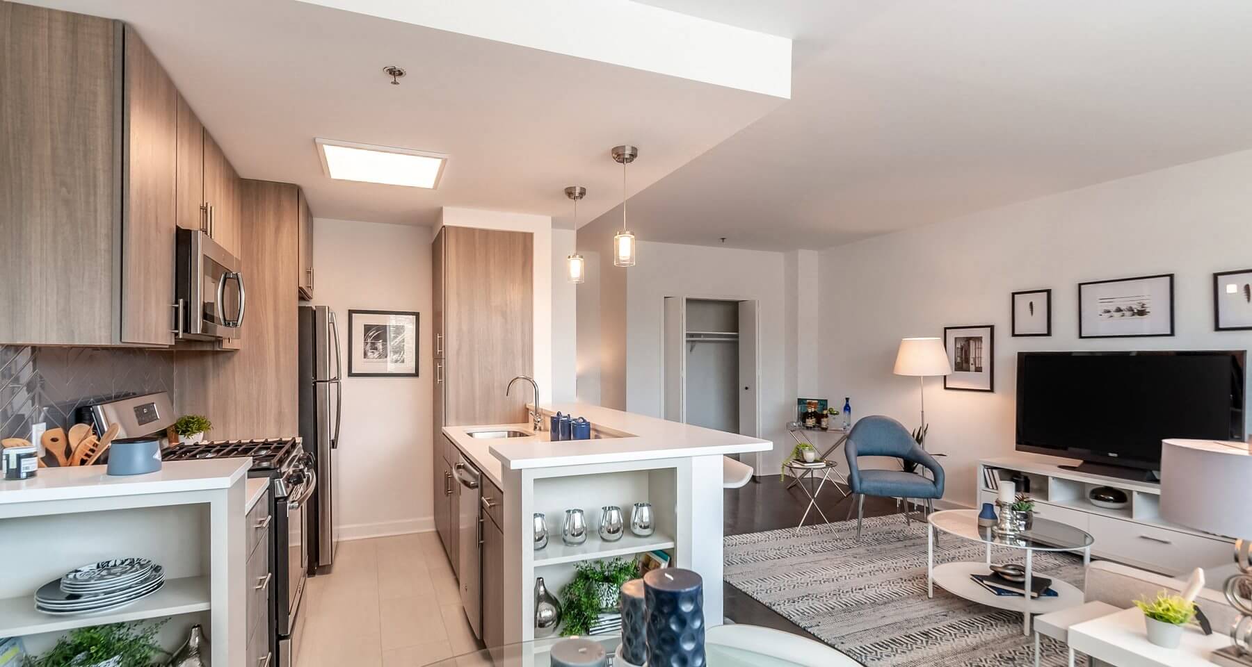 a kitchen and living room with a counter and a tv