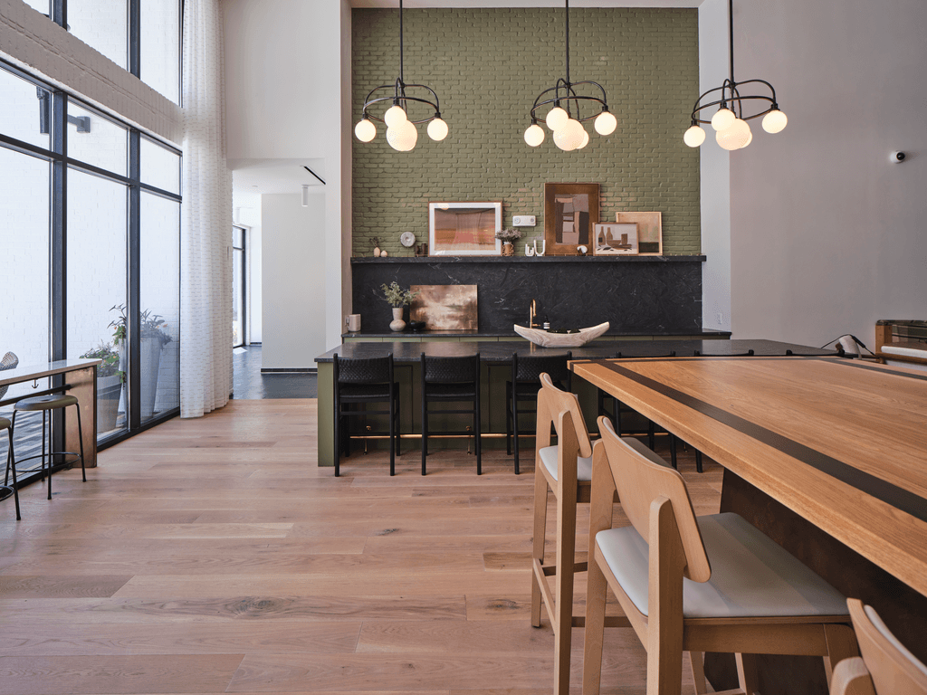 A modern dining room with a long wooden table and chairs.