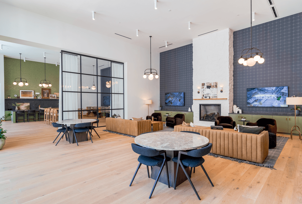 A modern living room with a white table and black chairs.
