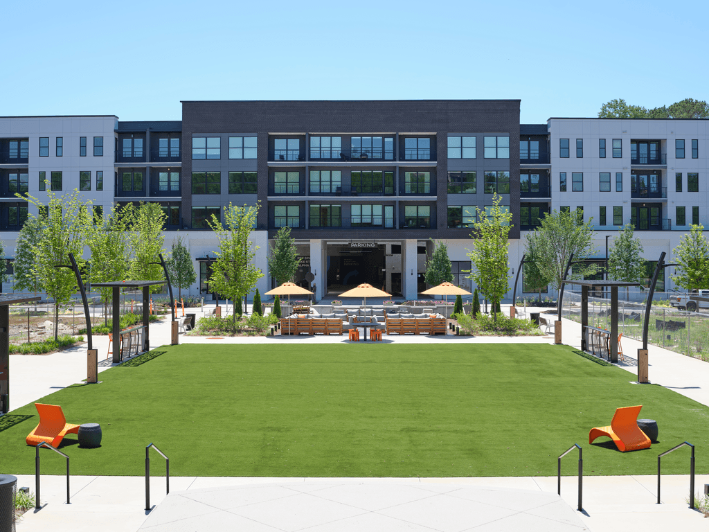 A large building with a green lawn in front of it.