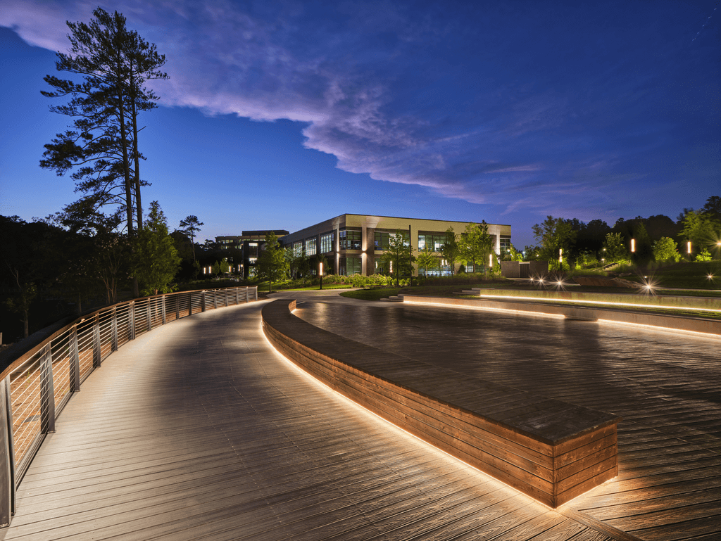 A wooden walkway leads to a building at night.