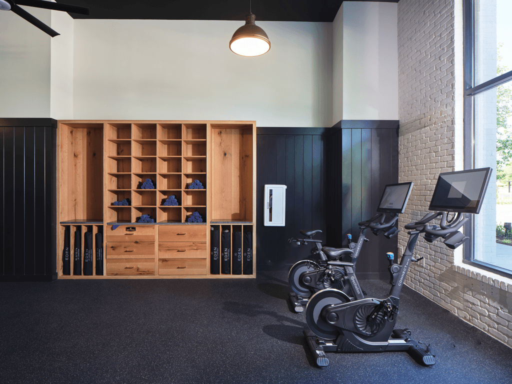A gym with a row of exercise bikes and a shoe rack.