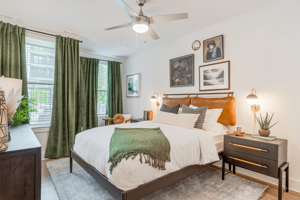 A bedroom with a bed, nightstand, and a ceiling fan.