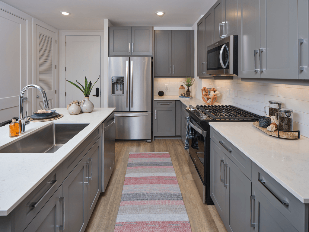 A modern kitchen with a striped rug on the floor.