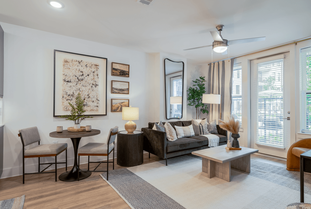 A living room with a grey couch, a coffee table, and a dining table with chairs.