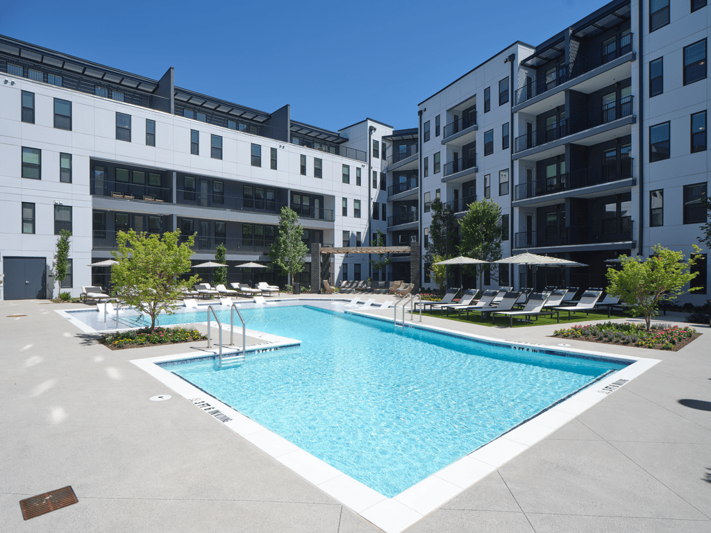 A swimming pool in a courtyard surrounded by buildings.
