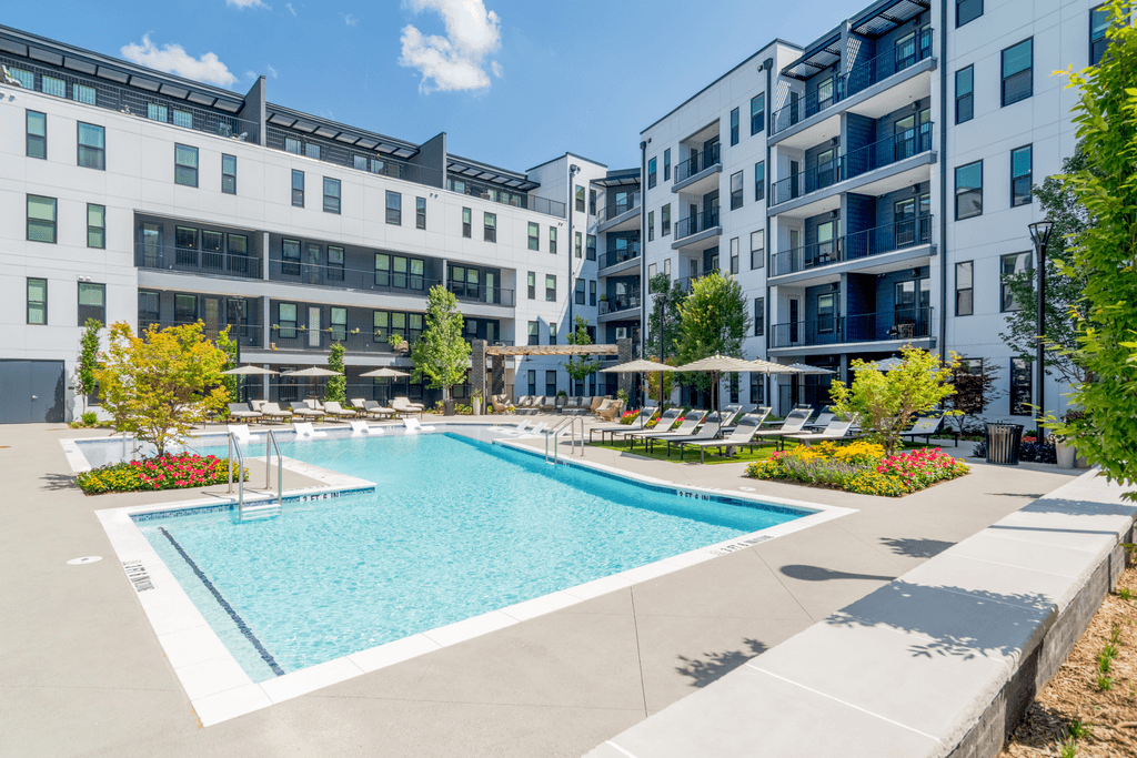 A swimming pool in front of apartment buildings.
