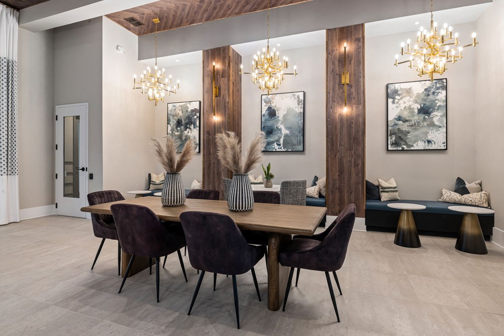 a dining room with a wooden table and chairs and chandeliers